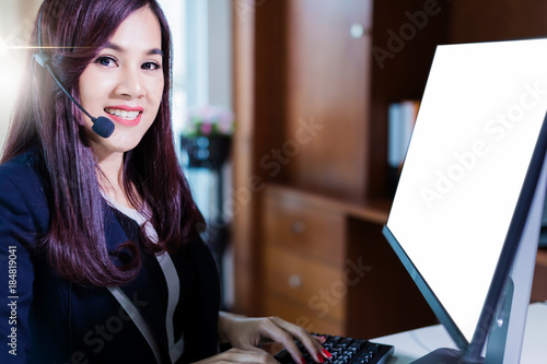 Smiling asian businesswoman using headset against elegane wooden interior room business ideas concept photo