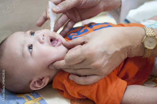 Oral vaccination of a baby boy photo