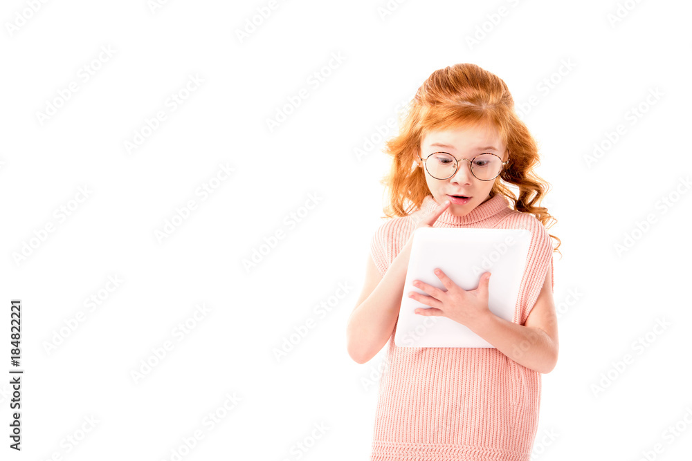 surprised redhead kid looking at tablet isolated on white surprised redhead kid looking at tablet isolated on white