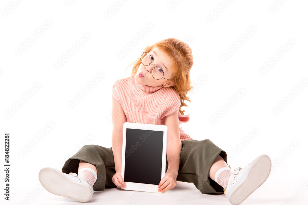 kid with ginger hair sitting and showing tablet on white kid with ginger hair sitting and showing tablet on white