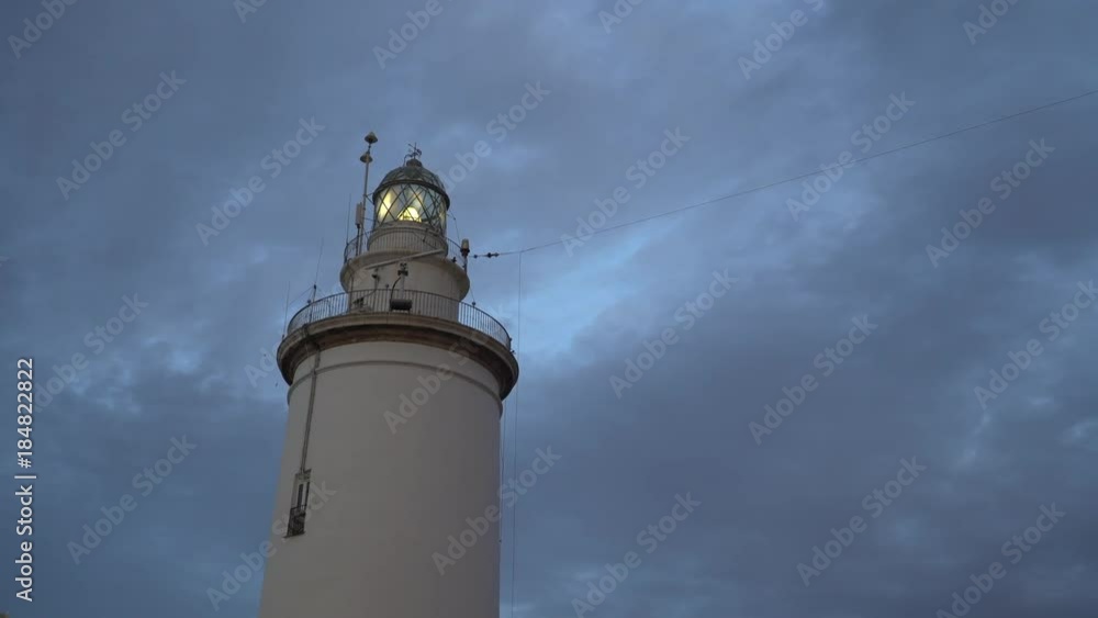 Working lighthouse in the port of Malaga, Spain at the evening Working lighthouse in the port of Malaga, Spain at the evening