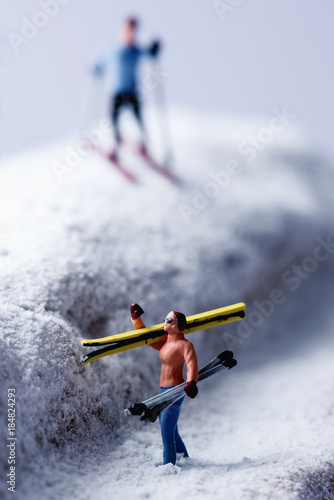 miniature skiers in a snowy landscape