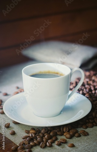 Coffee cup with coffee beans on a wooden table