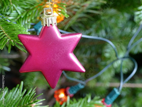 Close up of a red star decoration on a Christmas tree