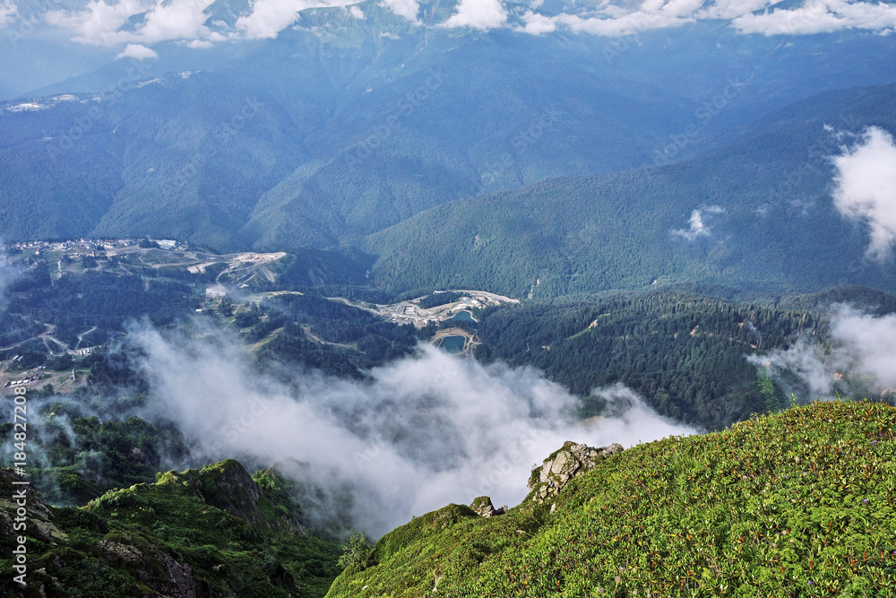 Panorama of the mountains in the area of Krasnaya Polyana/Panorama of Sochi in the Krasnaya Polyana area. There are mountains, clouds, air haze, vegetation. Sochi, Russia, mountain landscape Panorama of the mountains in the area of Krasnaya Polyana/Panorama of Sochi in the Krasnaya Polyana area. There are mountains, clouds, air haze, vegetation. Sochi, Russia, mountain landscape