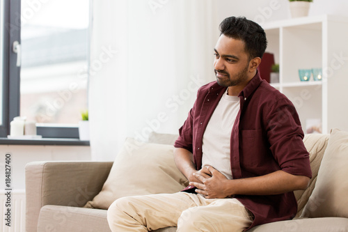 Fotografía unhappy man suffering from stomach ache at home