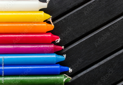 Wallpaper Mural Many colorful candles in a single row and line, black background, candles of vibrant white. yellow, orange, red and blue colors, in a rainbow gradient Torontodigital.ca