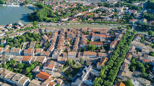 Aerial top view of residential area houses roofs, streets and canal with boats from above, old medieval town background, France 