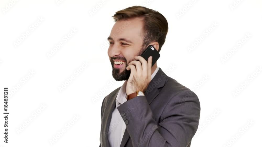 Portrait of happy brunette man in business outfit holding smartphone in hand having pleasant mobile conversation speaking with smiling over white background in studio closeup. Concept of emotions Portrait of happy brunette man in business outfit holding smartphone in hand having pleasant mobile conversation speaking with smiling over white background in studio closeup. Concept of emotions
