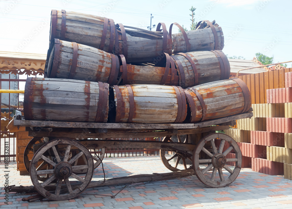 An old cart loaded with a lot of empty barrels