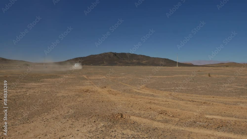 Cars driving on desolated road in empty desert landscape through the Atlas mountains in Morocco 4K Cars driving on desolated road in empty desert landscape through the Atlas mountains in Morocco 4K