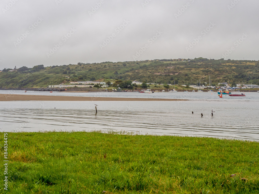 Boats moored at Poppit sands beach at high tide, Poppit Sands, St Dogmeals, Pembrokeshire, Wales, UK