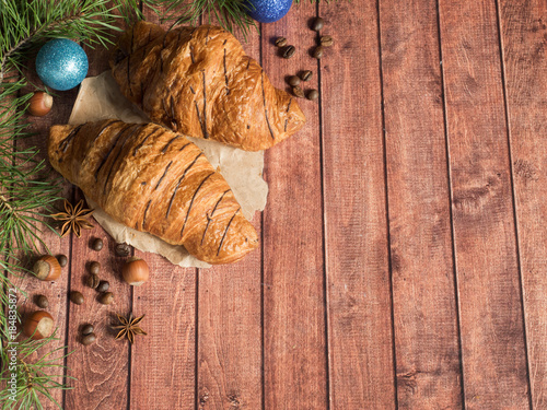 Christmas Breakfast croissant on a napkin. Dark wooden background. Christmas decorations Copy space