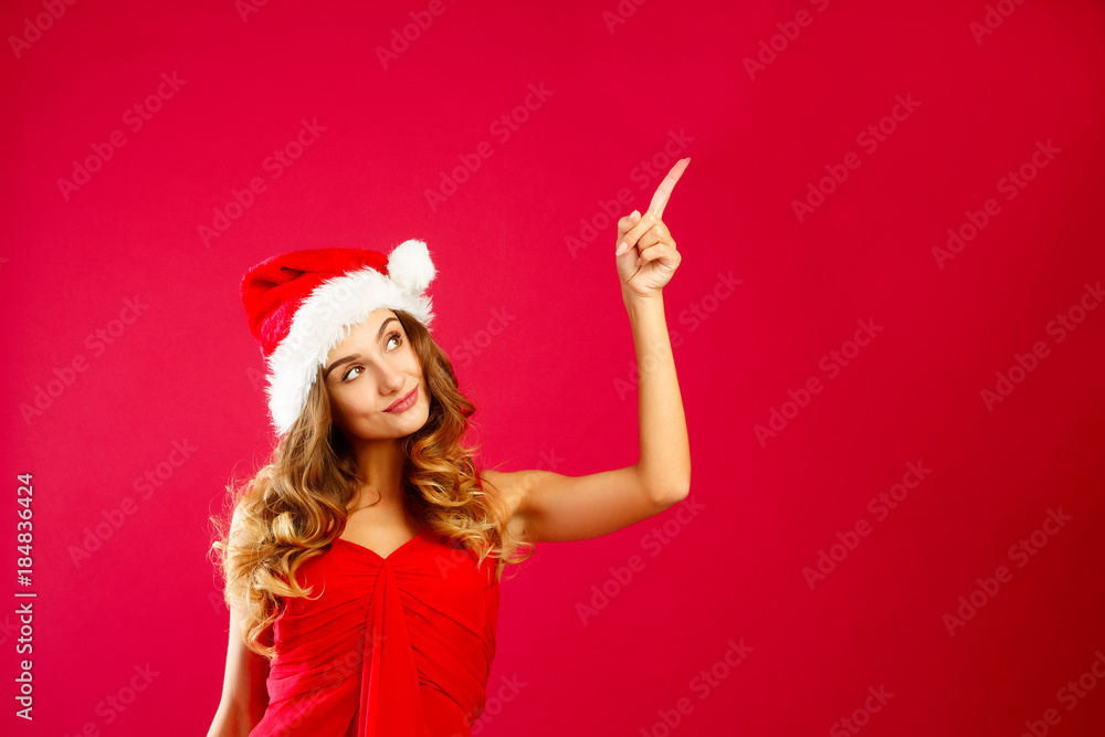 Young attractive Santa girl in red dress over red background Young attractive Santa girl in red dress over red background
