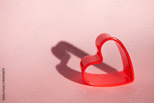 Red heart shape on pink background with copy space
