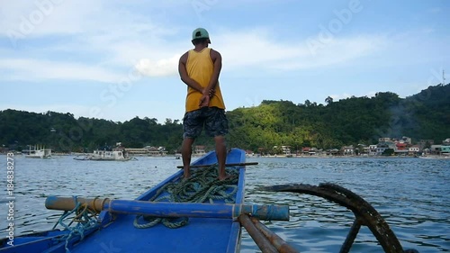 July 1st 2017, Filippino sailor standing on his boat as it sails to shore photo