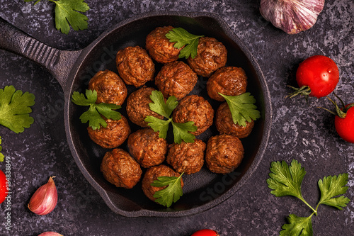 Roasted  meatballs with tomatoes, garlic and parsley.