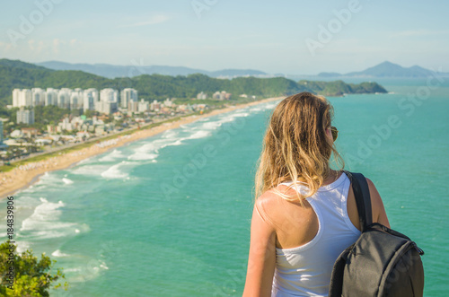 ótimo conceito de viajante, mochileiro, viajar, jovem mulher observando praia  photo