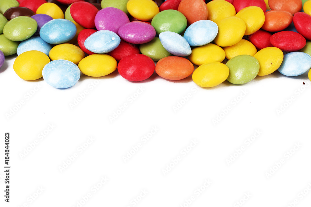 Obraz premium Chocolate candy candies background smarties on isolated white studio background. Closeup photo. Clipping path. Easy to use. White background. Cutout cut out. Smarties with text space.