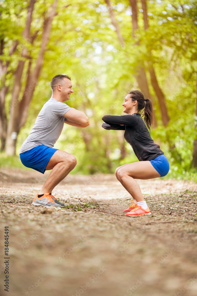 Fitness couple stretching outdoors in park - obrazy, fototapety, plakaty 