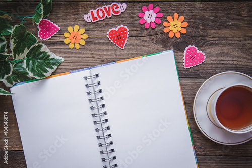 Festive layout for Valentine's day with hearts and Notepad on wooden background closeup
