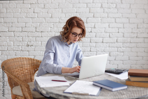 Young woman freelancer works at the computer.