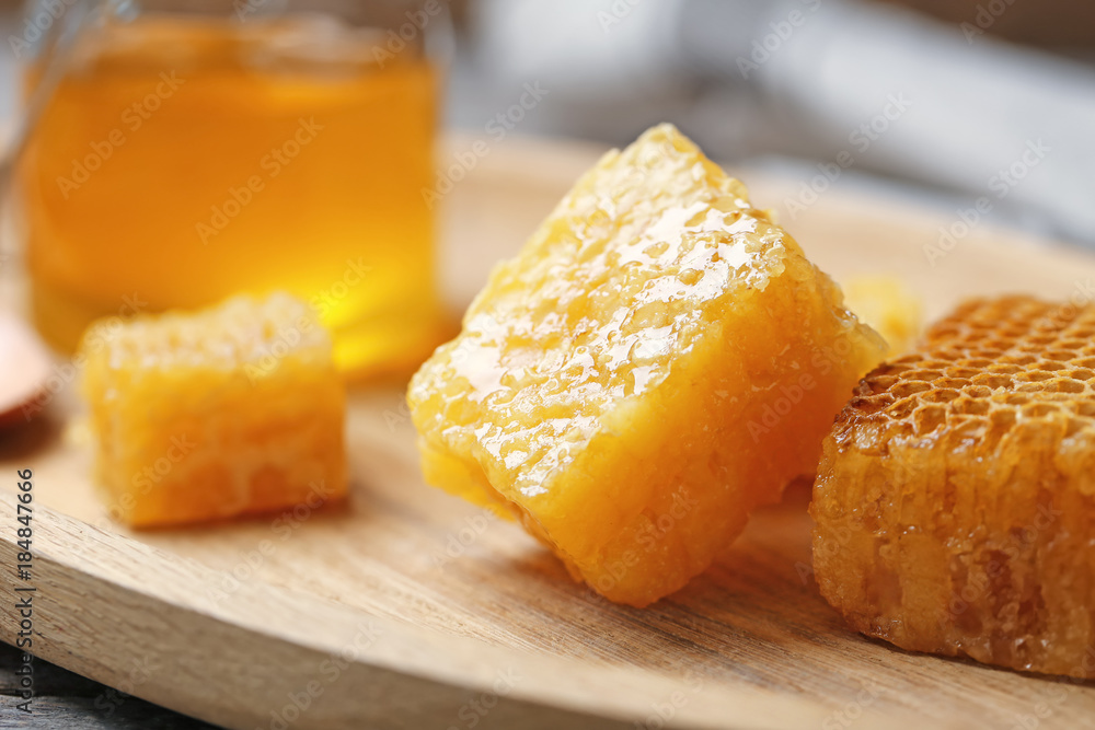 Fresh honeycombs on wooden board, closeup