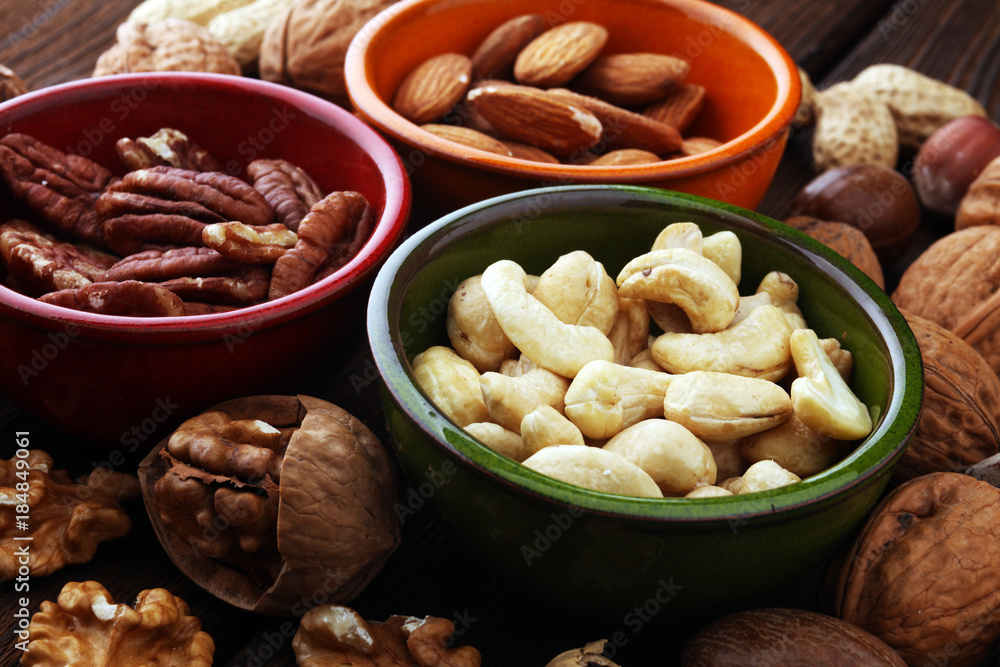 bowls with mixed nuts on wooden background. Healthy food and snack. Walnut, pecan, almonds, hazelnuts and cashews. bowls with mixed nuts on wooden background. Healthy food and snack. Walnut, pecan, almonds, hazelnuts and cashews.