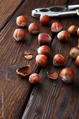 Hazelnut with peeled hazelnuts in burlap on textured wooden background