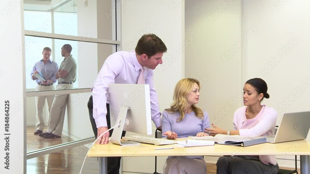 Group of coworkers at desk in busy office Group of coworkers at desk in busy office