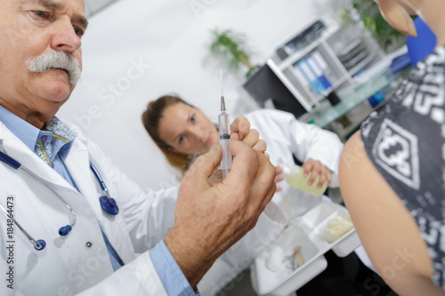 doctor holding an injection for a vaccine