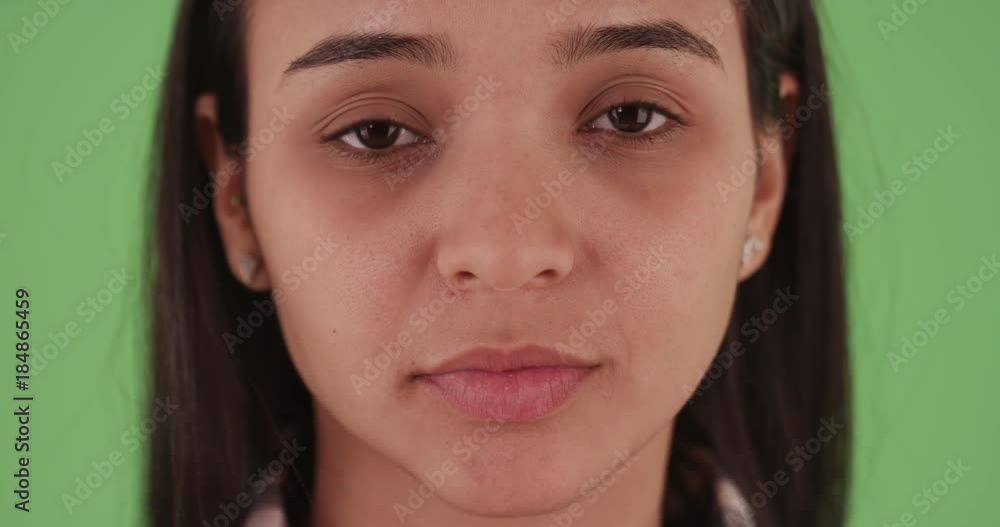 Close-up headshot of a Latina girl looking at the camera in plaid on green screen. On green screen to be keyed or composited. Close-up headshot of a Latina girl looking at the camera in plaid on green screen. On green screen to be keyed or composited.