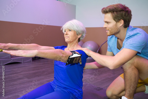 fit senior woman working out with coach