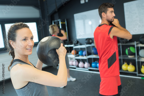 strong healthy woman holding heavy medicine ball in gym workout