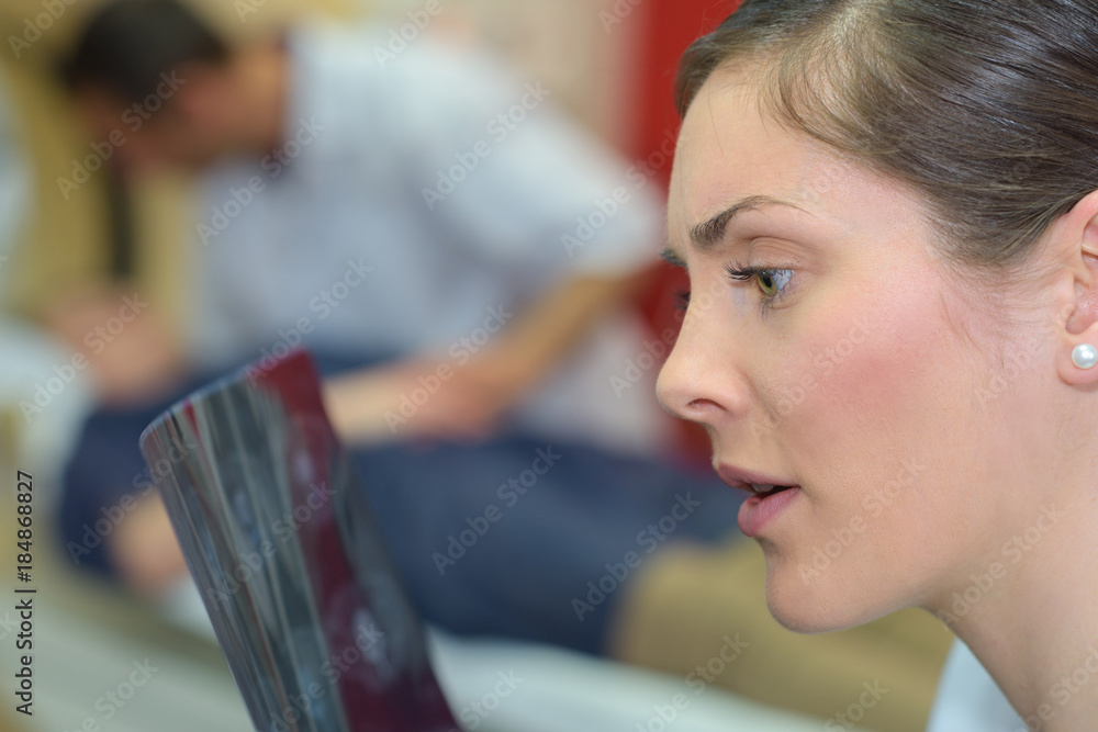 young female doctor looking surprised at an x-ray young female doctor looking surprised at an x-ray