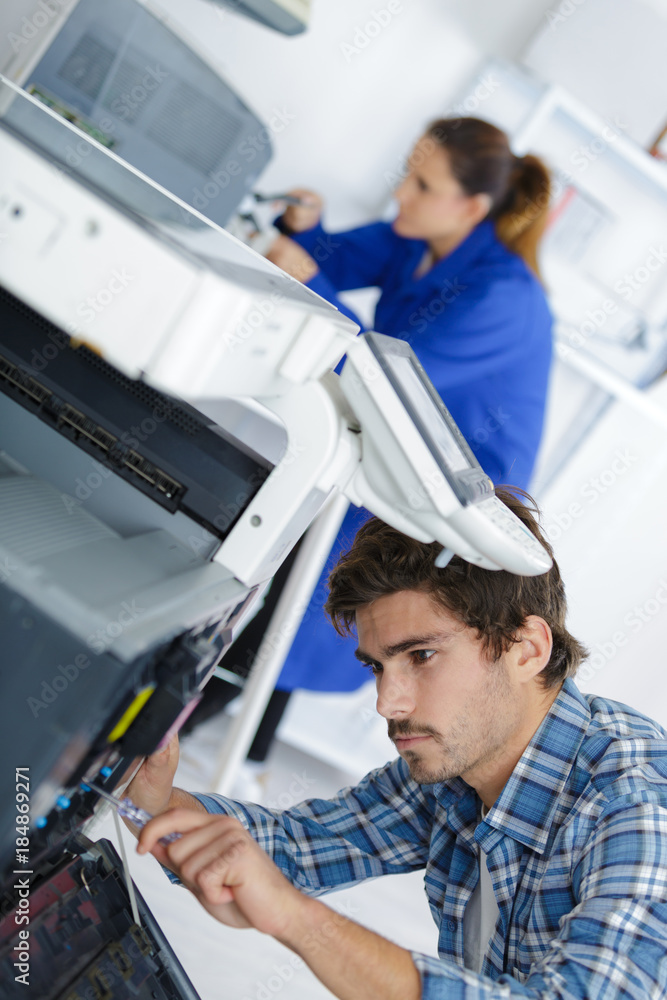 technician fixing broken photocopier machine technician fixing broken photocopier machine
