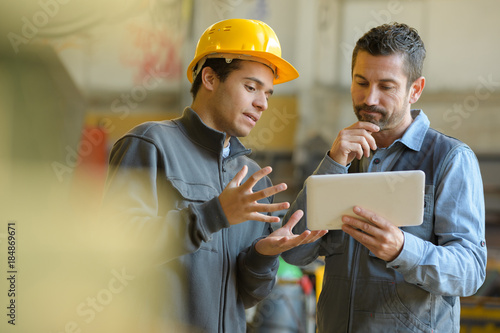 boss and worker checking results on the tablet photo