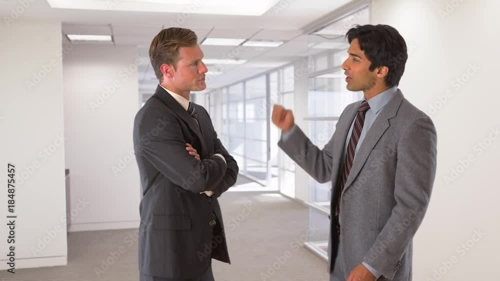 two businessmen standing and talking two businessmen standing and talking