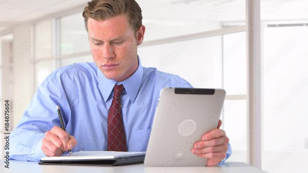 businessman writing notes and researching on tablet businessman writing notes and researching on tablet