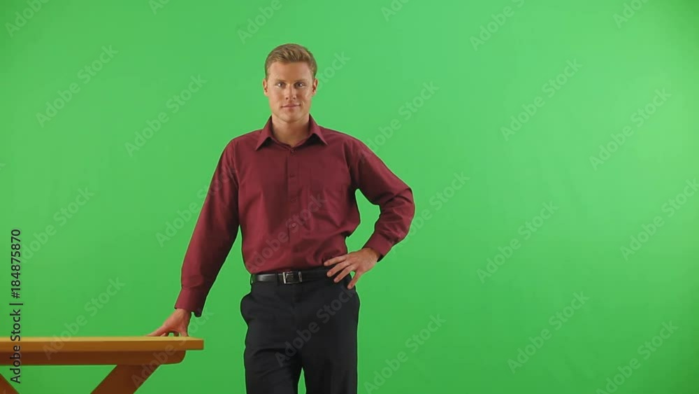 Businessman leaning on desk looking at camera Businessman leaning on desk looking at camera