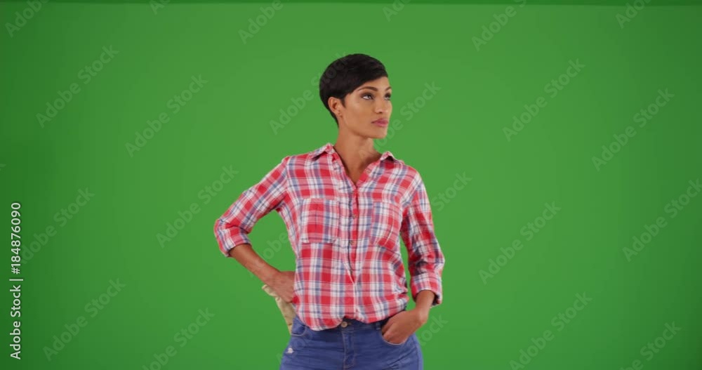 Young black woman dressed in flannel shirt with hands on hips, staring at camera on green screen. On green screen to be keyed or composited. Young black woman dressed in flannel shirt with hands on hips, staring at camera on green screen. On green screen to be keyed or composited.