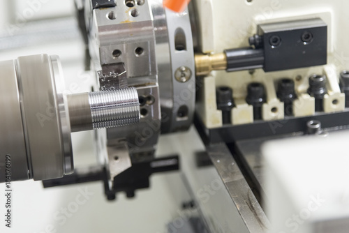 The CNC lathe machine cutting the thread of the pipe.