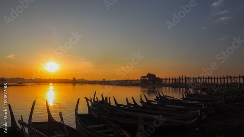 Sunset in U Bein bridge with vintage boat Myanmar. U Bein bridge is longest teak