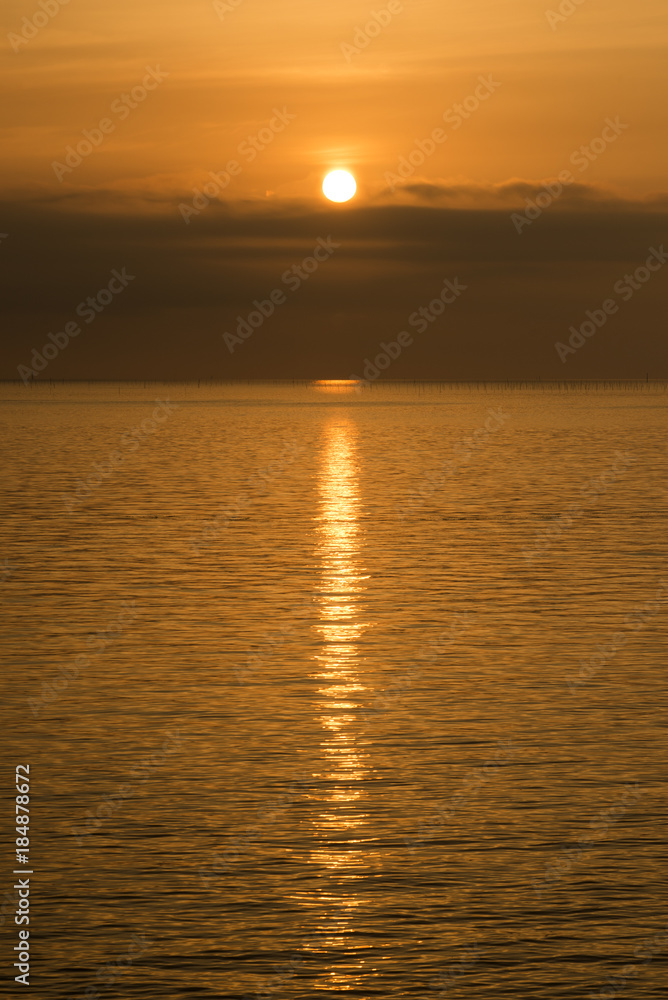 日の出直後の太陽と光の反射する有明海