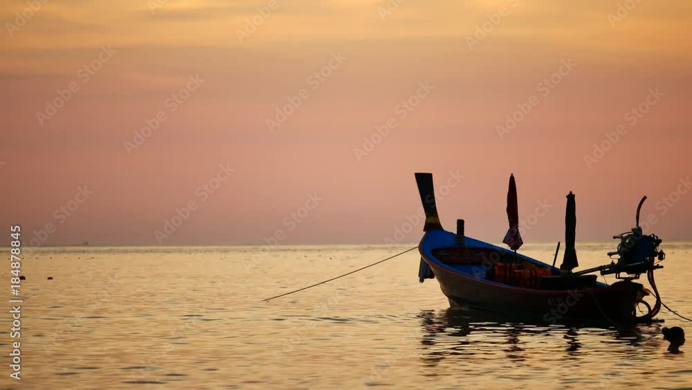 Travel Video silhouette long tail boat converted to boat excursions floating in the andaman sea with golden light of the Sun  before sunset in travel or transportation concept.