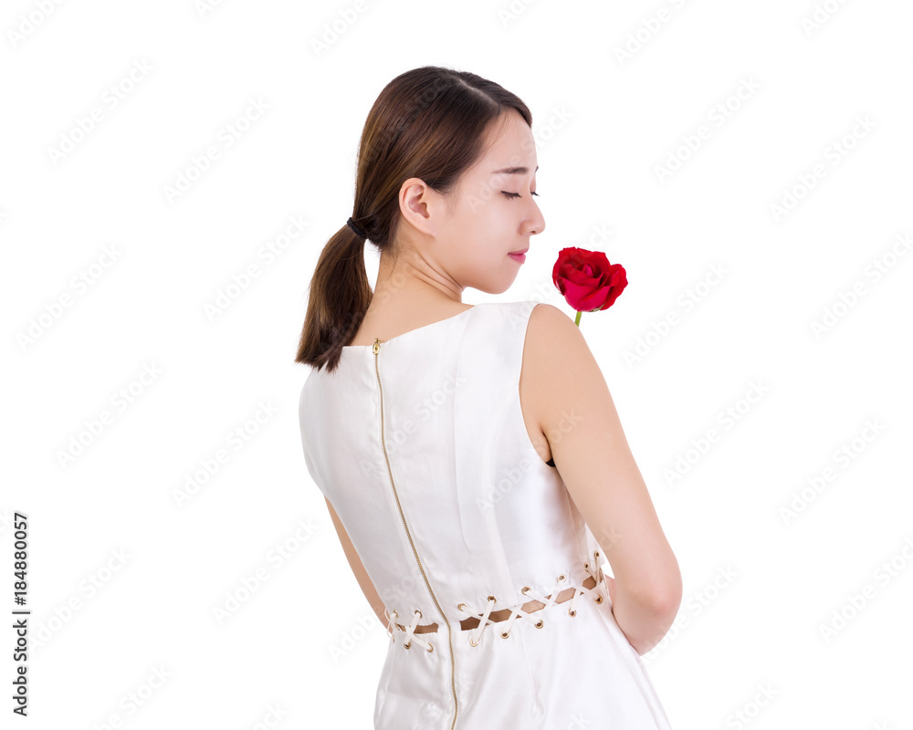 Beautiful woman holding a single red rose looking over her shoulder Beautiful woman holding a single red rose looking over her shoulder