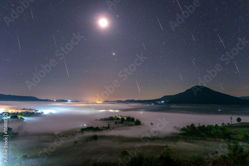 Geminid Meteor in the night sky with moon and fog at Khao Takhian Ngo View Point at Khao-kho Phetchabun,Thailand © sripfoto