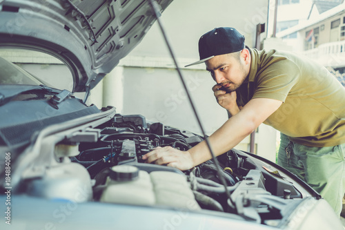 Mechanical fixing car at home. Repairing Service advice by mobile phone. Mechanic  technician man checking car engine. Car service  repair  fixing  maintenance working inspection vehicle concept. 