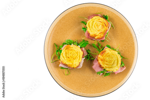 Stuffed frittata, cooked in the microwave oven, shaped like a rose, with rocket salad, speck, cooked ham (ingredients: eggs, cream, salt, emmental) on a white background photo