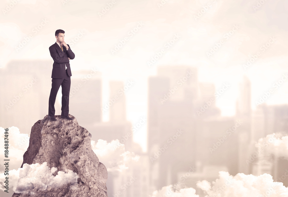Confident businessman on dangerous cliff Confident businessman on dangerous cliff